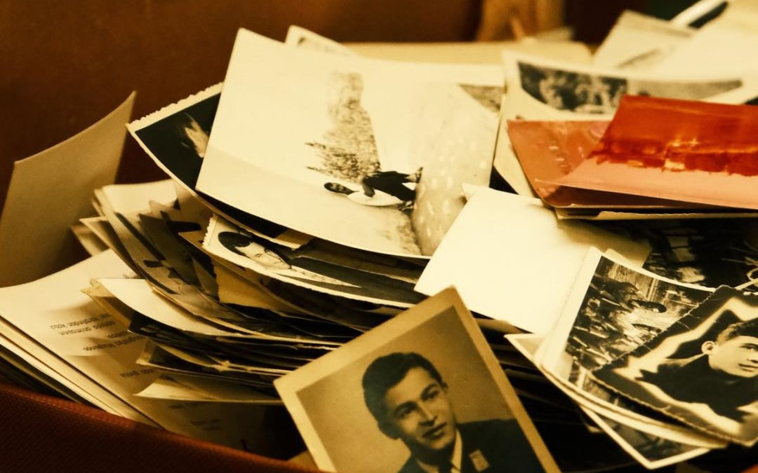 Pile de photographies anciennes en noir et blanc dans une valise ouverte